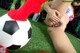 A woman laying on the grass next to a soccer ball.