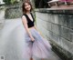 A woman in a black top and a pink tulle skirt.