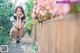 A woman sitting on a wooden walkway next to a fence.