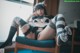 A woman in a cat costume sitting on a chair.