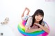 A young girl laying on an inflatable rainbow ring.