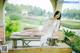 A woman in a white lingerie sitting on a wooden bench.