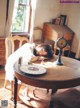 A woman laying on top of a table next to a clock.